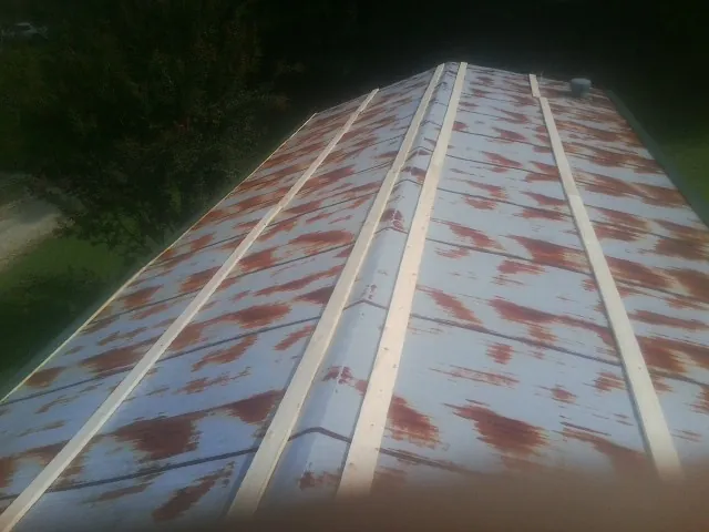 Rusted metal roof panels with new wood purlins before replacement — Storm Damage Roof Repair in Saranac by Roofing Brothers